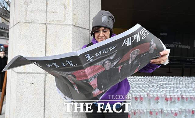 그룹 방탄소년단(BTS)의 컴백 라이브를 앞둔 21일 오후 서울 종로구 광화문 일대에서 외국인 관광객이 한 신문사가 발행한 BTS 관련 특별판을 들고 기념촬영을 하고 있다. /박헌우 기자