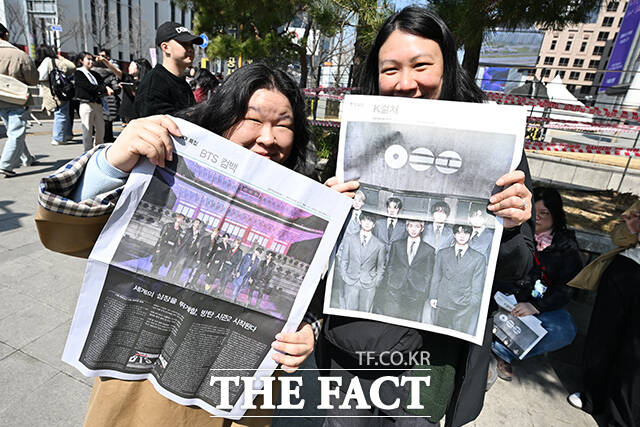 ‘BTS 컴백 라이브: 아리랑’ 개최 당일인 21일 오후 서울 중구 시청역 인근에서 외국인 관광객들이 신문사에서 발행한 BTS 관련 특별판을 들고 기념촬영을 하고 있다. /김성렬 기자