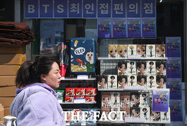 한 시민이 'BTS 최인접 편의점' 문구가 붙은 편의점 앞을 지나고 있다.