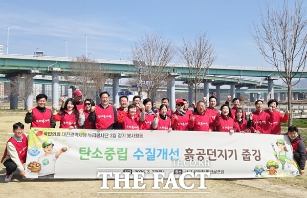 국민의힘 대전시당 누리봉사단이 세계 물의 날을 맞아 23일 대전 서구 유등천 파크골프장 일원에서 수질 개선 및 탄소중립 실천을 위한 환경정화 봉사활동을 펼친 뒤 기념촬영하고 있다. /국민의힘 대전시당