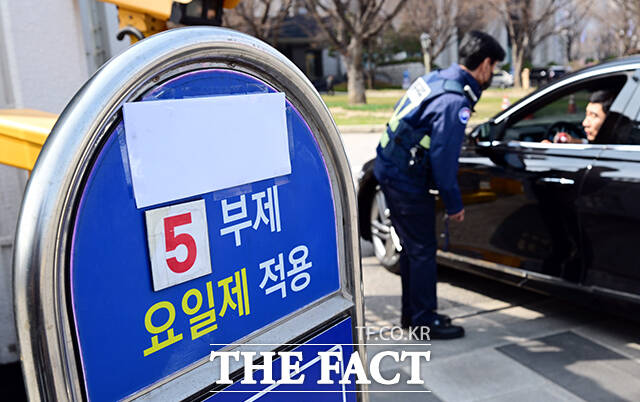 원유 자원안보 위기 '주의' 경보 발령으로 공공부문 '승용차 5부제 의무화'가 예고된 24일 오후 서울 종로구 정부서울청사 입구의 관계자들이 차량 5부제를 안내하고 있다. /임영무 기자