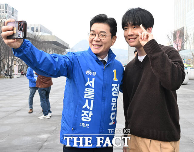 정원오 더불어민주당 서울시장 예비후보가 24일 오후 서울 종로구 광화문광장에서 퇴근길 시민들과 기념촬영하고 있다.