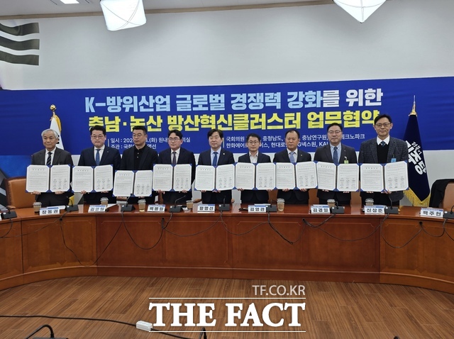 황명선 국회의원과 논산시 관계자, 방산기업 및 연구기관 대표들이 24일 국회에서 열린 방산혁신클러스터 유치 업무협약 체결 후 협약서를 들고 기념 촬영을 하고 있다. /충남도