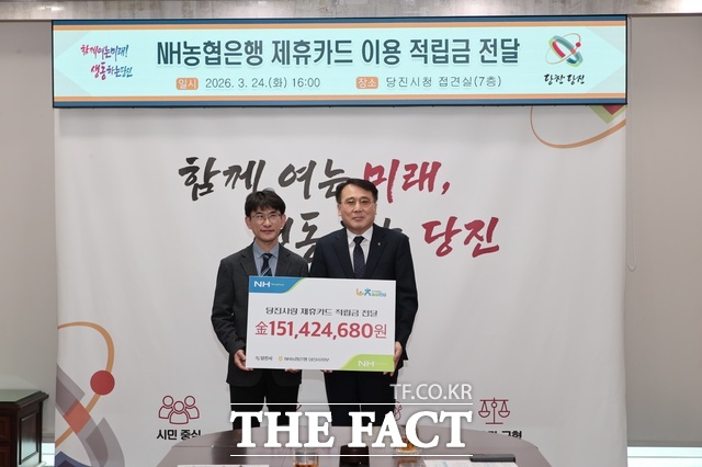 정광식 NH농협은행 당진시지부장(사진 오른쪽)이 24일 당진시청 접견실에서 황침현 당진시장 권한대행에게 제휴카드 이용 적립금 1억 5142만 원을 전달하고 있다. /당진시