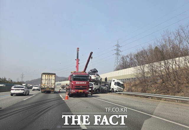26일 오후 충남 천안시 경부고속도로 서울 방향에서 화물차와 충돌한 뒤 보호난간을 뚫고 도로 밖으로 이탈한 카캐리어 차량을 대형 크레인으로 인양하고 있다. /정효기 기자