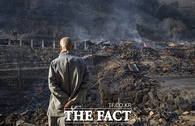 지난해 3월26일 경북 의성군 단촌면 고운사에 번진 산불로 가운루와 종각 등 건물들이 불에 타 흔적만 남은 가운데 고운사 스님이 화재 현장을 바라보고 있다. /의성=박헌우 기자