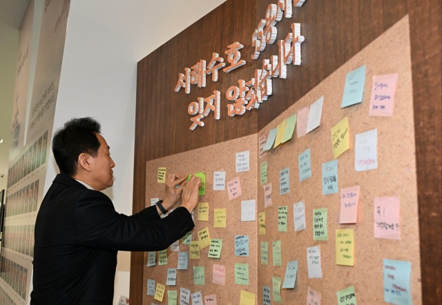 오세훈 서울시장이 27일 서울시청(지하1층 서울갤러리)에 마련된 ‘서해수호 55용사 추모공간’에서 추모 메시지를 부착하고 있다. /서울시