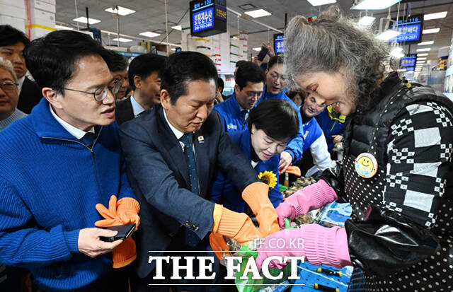 정청래 더불어민주당 대표(왼쪽 두 번째)와 박주민·전현희·정원오 (왼쪽부터) 서울시장 예비후보가 30일 서울 동작구 노량진수산물도매시장을 찾아 상인들과 인사하며 홍어를 들어보이고 있다. /이새롬 기자