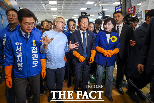 정청래 더불어민주당 대표(왼쪽 두 번째)와 박주민·전현희·정원오 (왼쪽부터) 서울시장 예비후보가 30일 서울 동작구 노량진수산물도매시장을 찾아 상인들과 인사하며 홍어를 들어보이고 있다. /이새롬 기자