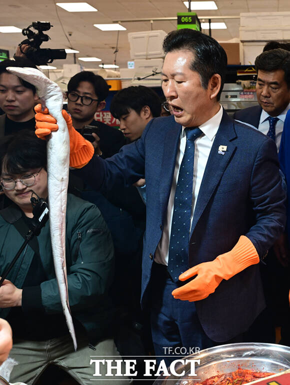 정청래 더불어민주당 대표(왼쪽 두 번째)와 박주민·전현희·정원오 (왼쪽부터) 서울시장 예비후보가 30일 서울 동작구 노량진수산물도매시장을 찾아 상인들과 인사하며 홍어를 들어보이고 있다. /이새롬 기자