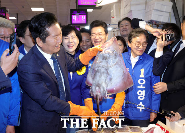 정청래 더불어민주당 대표(왼쪽 두 번째)와 박주민·전현희·정원오 (왼쪽부터) 서울시장 예비후보가 30일 서울 동작구 노량진수산물도매시장을 찾아 상인들과 인사하며 홍어를 들어보이고 있다. /이새롬 기자