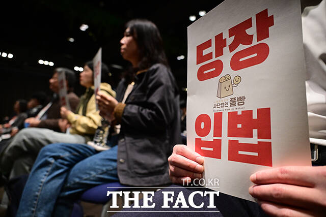 이날 열린 '권리 밖 노동 보호를 위한 패키지 입법 간담회'의 참가자가 해당 법안의 빠른 입법을 촉구하며 손팻말을 들고 있다.