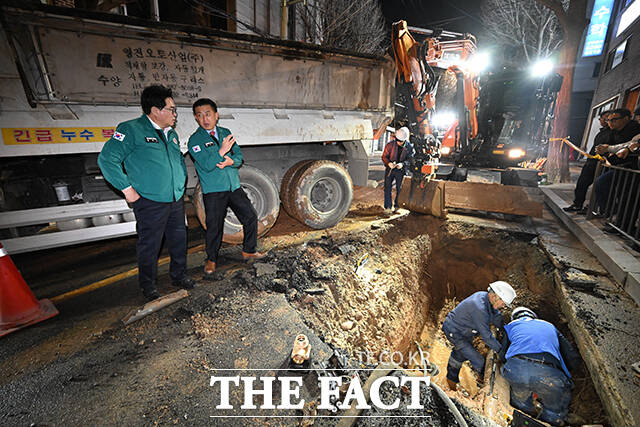 박일하 동작구청장(왼쪽)이 31일 오후 서울 동작구 여의대방로 36길 일대에서 발생한 노후상수도관 파손 사고 현장을 살펴보고 있다. /박헌우 기자