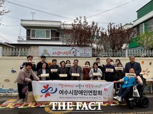 여수시장애인연합회 관계자들이 후원 전달식에서 서녹씨 딸기모찌가 지원한 딸기모찌를 들고 기념 촬영을 하고 있다. /여수시장애인연합회