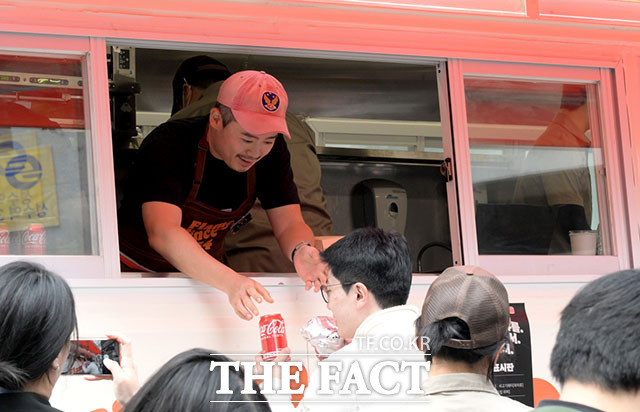 유용욱 셰프가 1일 오전 서울 성수동에서 ‘게릴라 와퍼트럭’을 타고 시민들에게 신제품을 제공하고 있다. 유 셰프는 자신의 시그니처인 비프립 노하우와 버거킹의 직화 방식을 결합해 고유의 풍미를 구현했다.