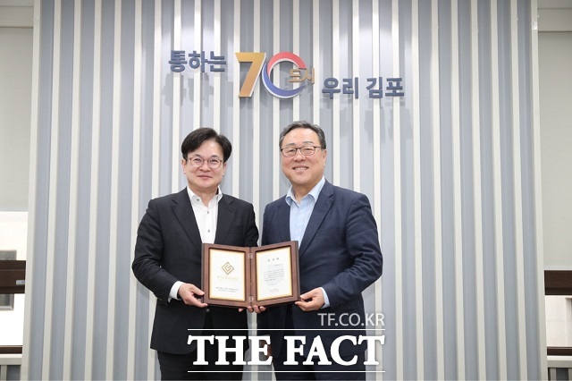 김병수 김포시장(왼쪽)이 지난달 30일 김포시청에서 시석중 경기신용보증재단 이사장으로부터 감사패를 받은 뒤 기념사진을 찍고 있다. /김포시