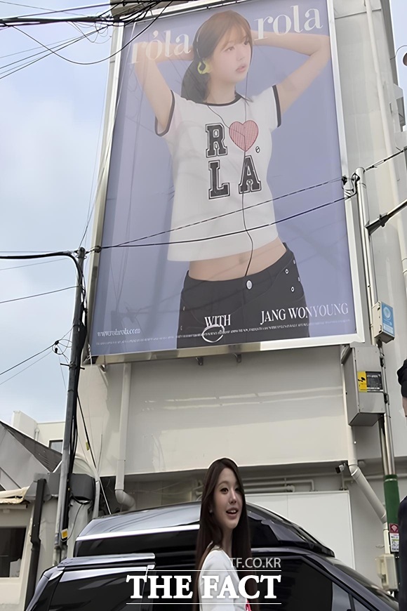 1일 오승혁의 현장은 서울 종로구 서촌에서 열린 아이브 장원영의 로라로라 팝업 스토어 오픈 행사를 찾았다. 행사를 마치고 나와 차량에 타던 중 본인의 대형 포스터가 걸린 것을 보고 미소 짓는 장원영의 모습. /서울 종로구=오승혁 기자