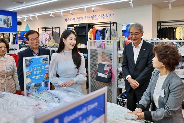 우리금융그룹 창립 25주년을 맞아 굿윌스토어 밀알우리금융점에서 그룹 모델 아이유(왼쪽에서 세번째), 임종룡 우리금융그룹 회장(오른쪽에서 두번째)이 남대문시장 소상공인 대표들과 대화하고 있다./우리금융