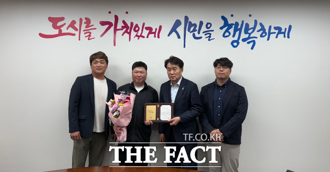 하은호 군포시장(우측에서 두번째)이 1일 폐기물 속 거액의 현금을 주인에게 찾아준 환경미화원 배영제 씨에게 표창을 전달한 뒤 기념촬영을 하고 있다. /군포시