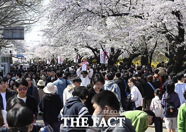 한 커플이 인형과 사진을 찍고 있다.