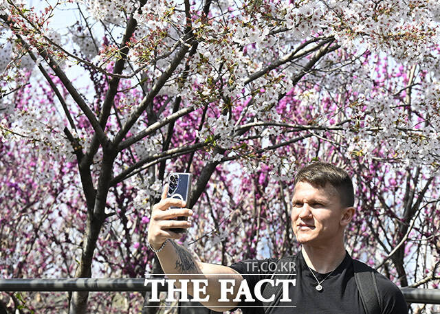 한 커플이 인형과 사진을 찍고 있다.