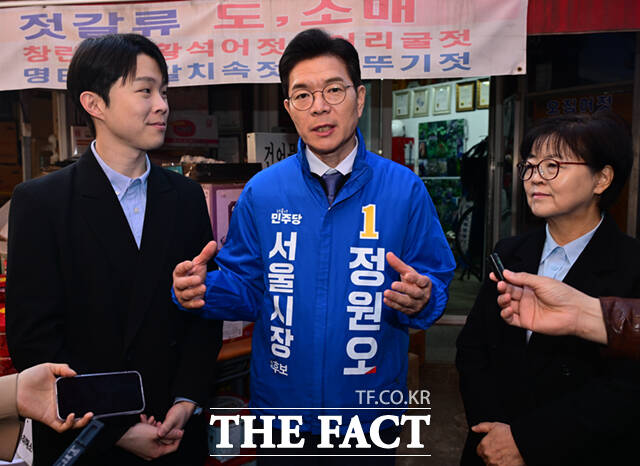 정원오 더불어민주당 서울시장 예비후보(왼쪽)가 6일 오후 서울 강북구 수유시장에서 김형남 전 서울시장 예비후보로부터 정책제안서를 받고 있다. /이새롬 기자