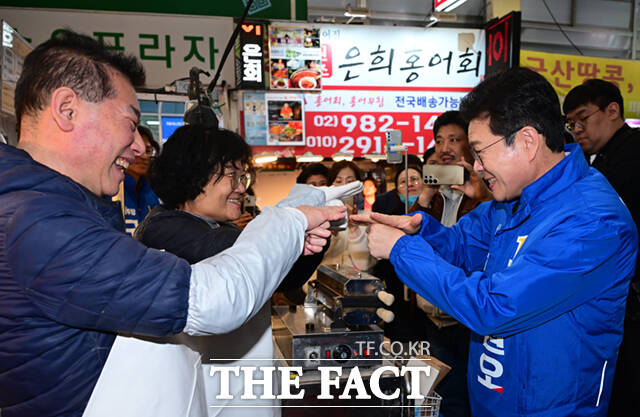 정원오 더불어민주당 서울시장 예비후보가 6일 오후 서울 강북구 수유시장을 찾아 농인 상인 부부와 수어로 인사하고 있다. /이새롬 기자