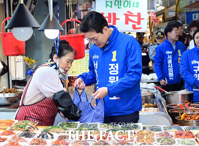 정원오 더불어민주당 서울시장 예비후보가 6일 오후 서울 강북구 수유시장을 찾아 농인 상인 부부와 수어로 인사하고 있다. /이새롬 기자