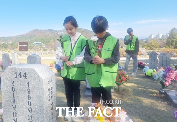 유서민 씨가 5일 국립대전현충원에서 봉사활동하는 가운데 쌍둥이 아이들이 호국영령에게 헌화하고 있다. /선치영 기자