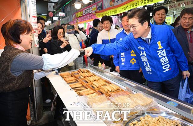 정원오 더불어민주당 서울시장 예비후보가 6일 오후 서울 강북구 수유시장을 찾아 농인 상인 부부와 수어로 인사하고 있다. /이새롬 기자