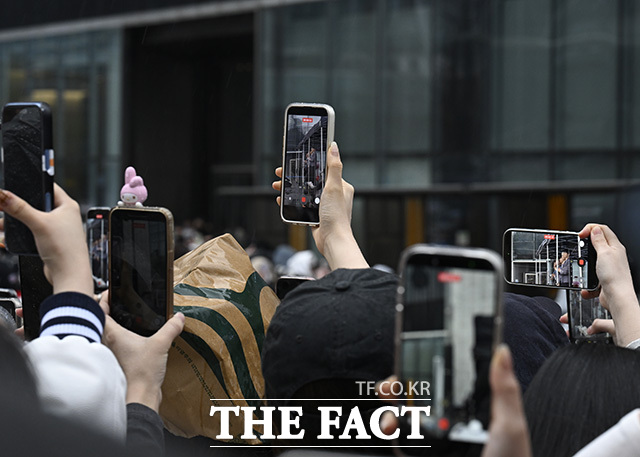 팬들이 멤버들의 사진을 찍고 있다.