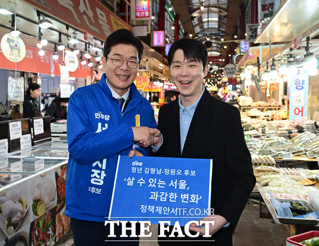 정원오 더불어민주당 서울시장 예비후보(왼쪽)가 6일 오후 서울 강북구 수유시장에서 김형남 전 서울시장 예비후보로부터 정책제안서를 받고 있다. /이새롬 기자