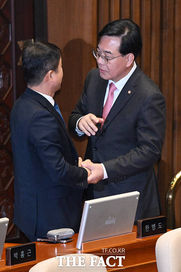송언석 국민의힘 원내대표(오른쪽)가 6일 오후 국회 본회의장에서 열린 경제 분야 대정부질문에서 한병도 더불어민주당 원내대표를 찾아가 손을 잡고 대화를 나누고 있다. /국회=서예원 기자