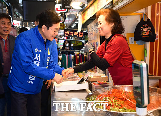 정원오 더불어민주당 서울시장 예비후보가 6일 오후 서울 강북구 수유시장을 찾아 농인 상인 부부와 수어로 인사하고 있다. /이새롬 기자
