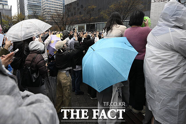 팬들이 멤버들의 사진을 찍고 있다.