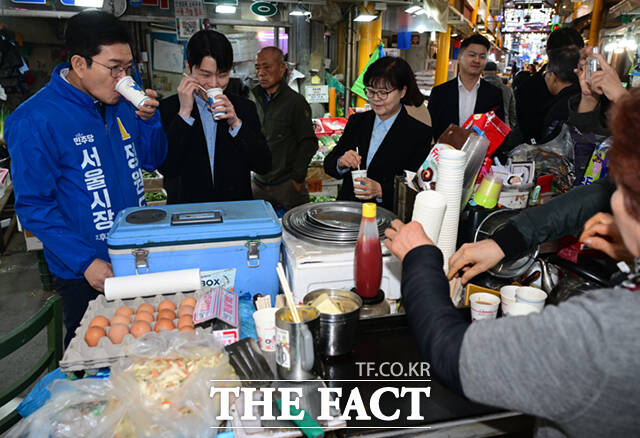 정원오 더불어민주당 서울시장 예비후보가 6일 오후 서울 강북구 수유시장을 찾아 농인 상인 부부와 수어로 인사하고 있다. /이새롬 기자