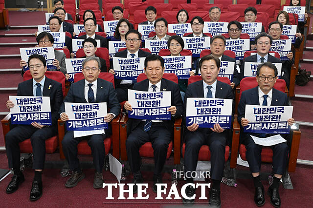 정청래 더불어민주당 대표(가운데)를 비롯한 참석자들이 7일 오전 서울 여의도 국회 의원회관에서 열린 민주당 기본사회위원회 3기 출범식에서 손피켓을 들고 구호를 외치고 있다. /국회=서예원 기자