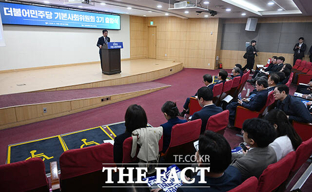 정청래 더불어민주당 대표(가운데)를 비롯한 참석자들이 7일 오전 서울 여의도 국회 의원회관에서 열린 민주당 기본사회위원회 3기 출범식에서 손피켓을 들고 구호를 외치고 있다. /국회=서예원 기자