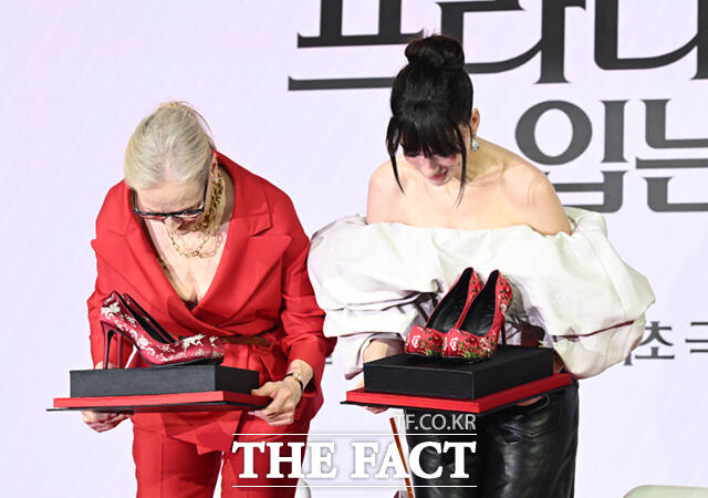 배우 메릴 스트립(왼쪽)과 앤 해서웨이가 8일 서울 광화문 포시즌스 호텔 서울에서 열린 영화 '악마는 프라다를 입는다2' 내한 기자간담회에서 제작진이 선물로 준비한 꽃신 하이힐을 받고 고개 숙여 인사하고 있다.