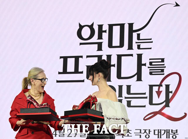 배우 메릴 스트립(왼쪽)과 앤 해서웨이가 8일 서울 광화문 포시즌스 호텔 서울에서 열린 영화 '악마는 프라다를 입는다2' 내한 기자간담회에서 제작진이 선물로 준비한 꽃신 하이힐을 받고 고개 숙여 인사하고 있다.