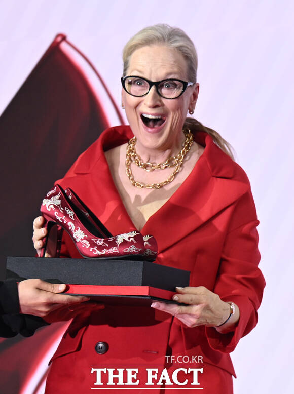 배우 메릴 스트립(왼쪽)과 앤 해서웨이가 8일 서울 광화문 포시즌스 호텔 서울에서 열린 영화 '악마는 프라다를 입는다2' 내한 기자간담회에서 제작진이 선물로 준비한 꽃신 하이힐을 받고 고개 숙여 인사하고 있다.