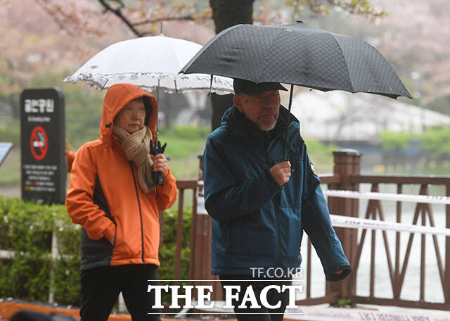 봄비가 이틀째 이어진 10일 오전 서울 송파구 석촌호수공원을 찾은 시민들이 우산을 쓰고 둘레길을 산책하고 있다. /박상민 기자