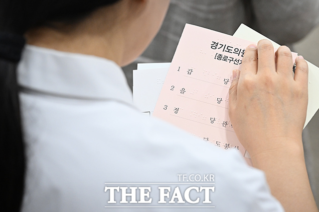 유권자가 점자투표보조용구를 이용해 후보들을 확인하고 있다.