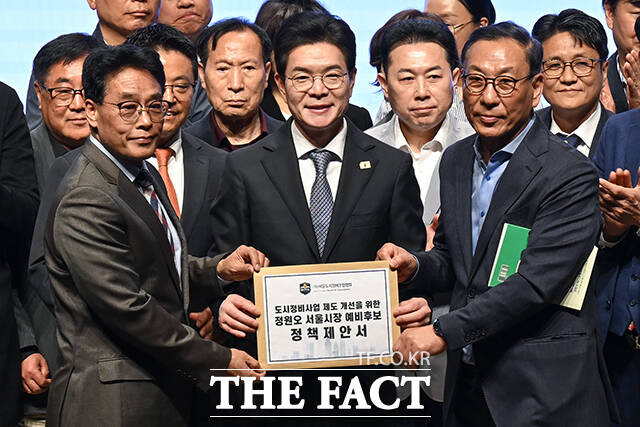 정한호 서울도시정비조합협회 이사장(왼쪽)이 정원오 서울시장 후보에게 '도시정비사업 제도 개선을 위한 정책제안서'를 전달하는 모습.