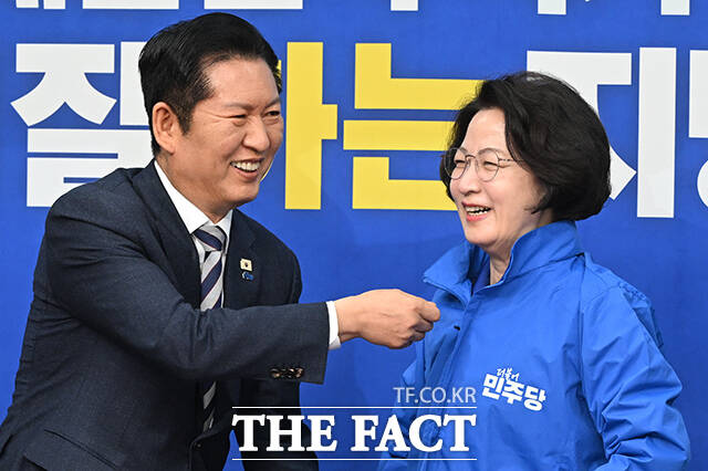 정청래 더불어민주당 대표(왼쪽)가 13일 오전 서울 여의도 국회에서 열린 최고위원회의에 앞서 추미애 경기도지사 후보에게 당 점퍼를 입혀주고 있다. /국회=김성렬 기자