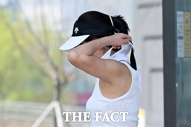 한 시민이 얇은 옷차림으로 발걸음을 옮기고 있다.