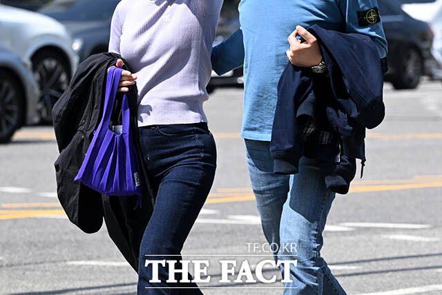 시민들이 겉옷을 들고 이동하고 있다.