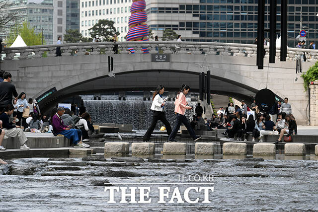 서울 낮 최고 기온이 28도까지 오른 14일 오후 서울 종로구 청계천에서 한 직장인이 청계천에 발을 담그고 있다. /박상민 기자