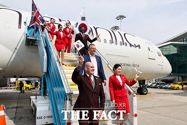 영국 버진애틀랜틱의 런던 히드로발 항공기에서 최고경영자 코닐 코스터(맨 위)와 승무원들이 취항을 기념하며 인사하고 있다. /공항사진기자단