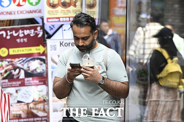 한 외국인 관광객이 음료를 들고 있다.